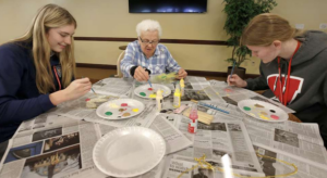 Students painting with resident