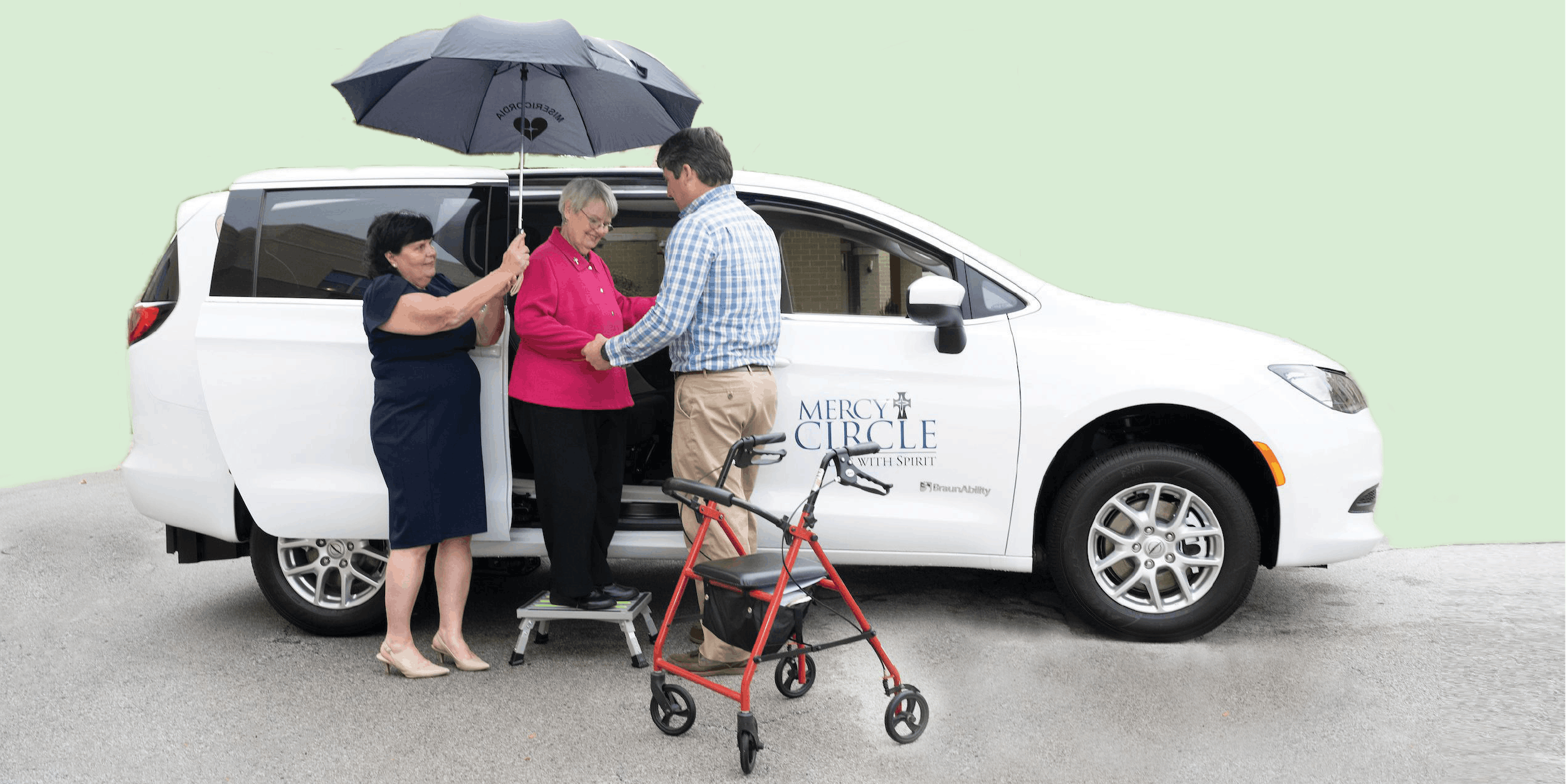 Two people helping a senior citizen out of a van