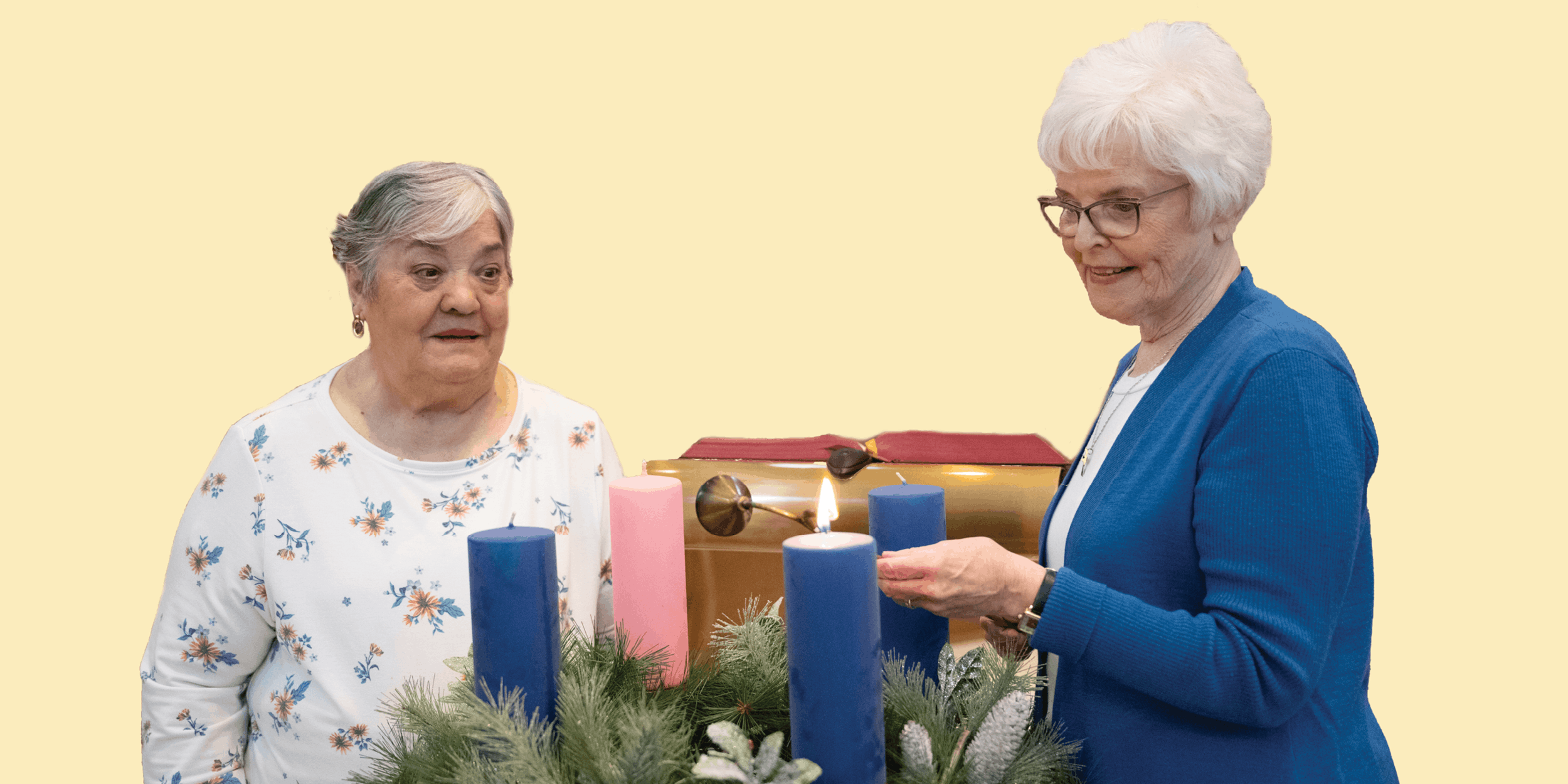 Two women lighting a candle