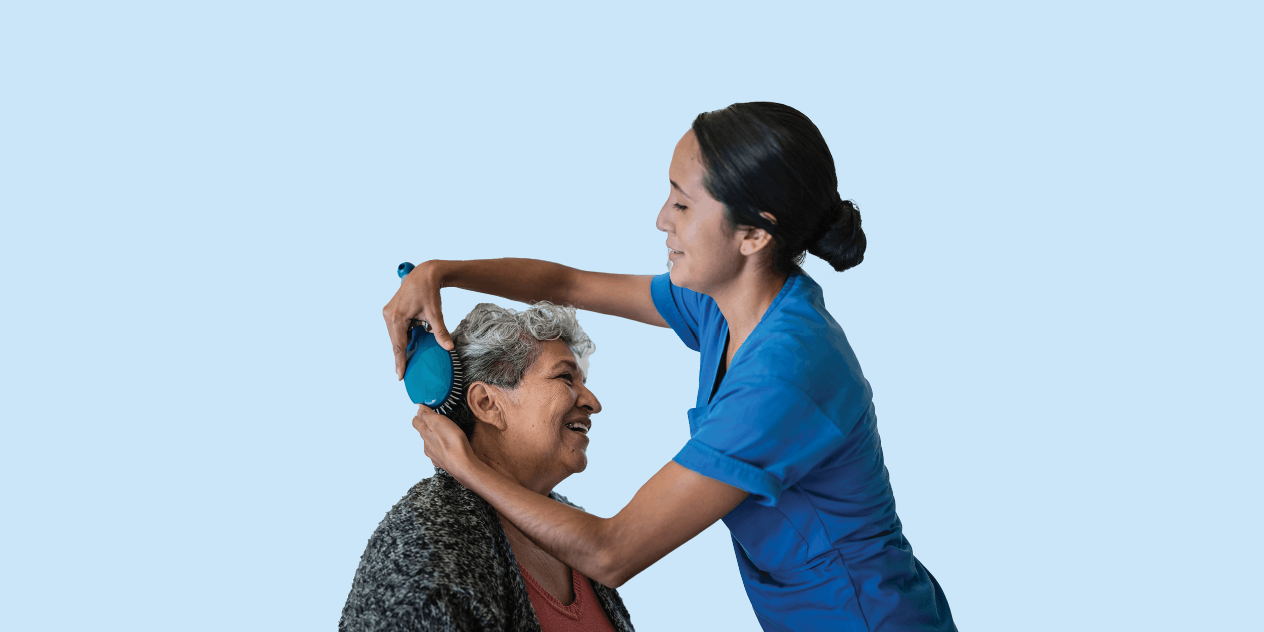 Nurse brushing a female resident's hair