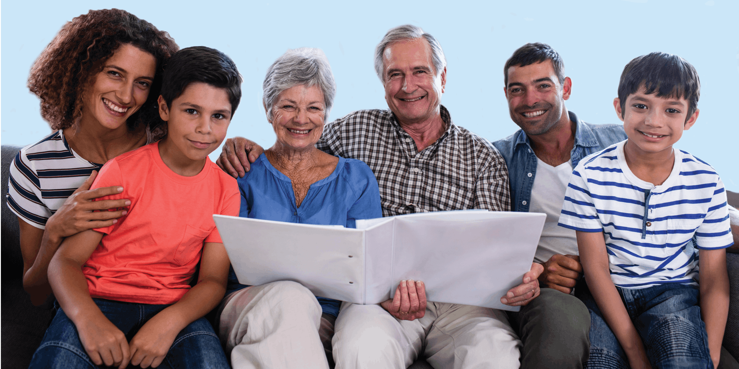 Family on a couch with two grandparents holding a binder